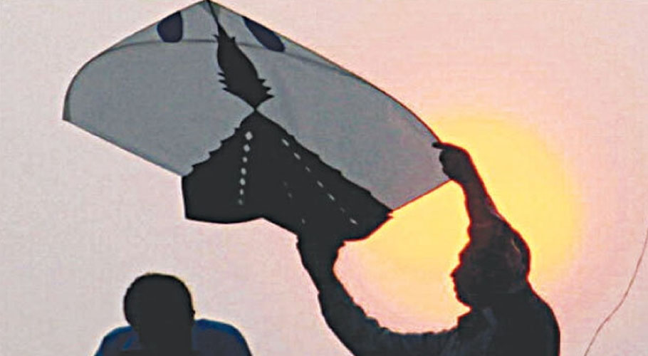 ایک شخص پٹنگ اڑانے کی تیاری کر رہا ہے