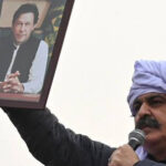 علی امین گنڈاپور عمران خان کی تصویر کا پوسٹر اٹھائے ہوئے