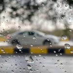 بارش کے دوران کراچی کی سڑک پر ایک کار گزر رہی ہے
